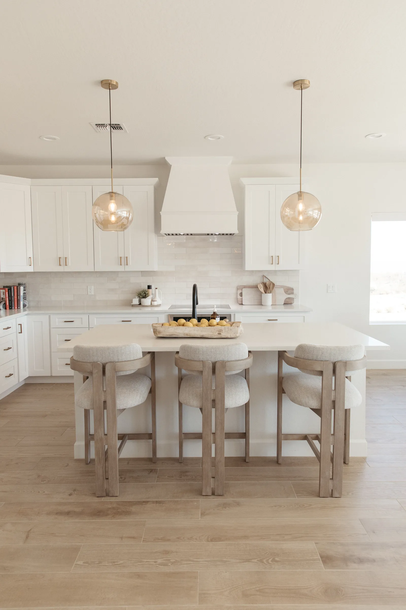 White kitchen with glass pendants and island seating
